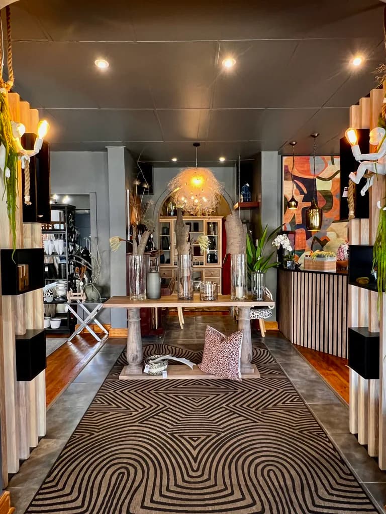 Free State Curtain Parlour showroom entrance with a console table, rug, lighting and decor displays