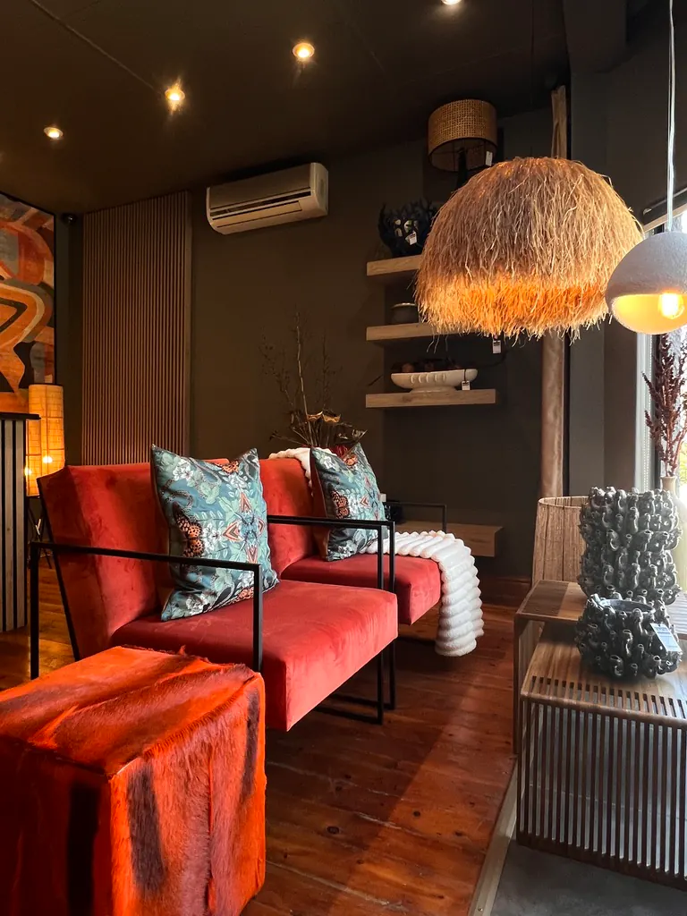 Red upholstered chairs, patterned cushions, pendant lighting and decor in the Free State Curtain Parlour showroom in Bloemfontein